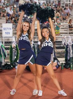 two cheerleaders perform at a football game