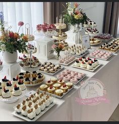 a table topped with lots of cakes and cupcakes