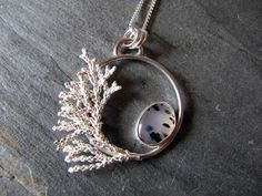 "This pendant is made with sterling silver, a Montana agate, and some cast cypress. I purchased the stone on a recent trip to Montana from the man who found the rock along the Yellowstone River, cut, and polished it.   I created a circle from round wire, added the bezel set agate on the inside and the cypress sprig on the edge.  The cypress came from a tree in my yard.  I cast it in solid sterling silver so that it is the exact replica of the plant. The pendant measures approx. 1 1/2\". The ster Yellowstone River, Art Jewelry Contemporary, Montana Agate, Beaded Jewels, Precious Metal Clay, Electroformed Jewelry, Aquamarine Jewelry, Tree Pendant, Silver Jewelry Handmade