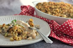 a white plate topped with food next to a casserole dish filled with stuffing