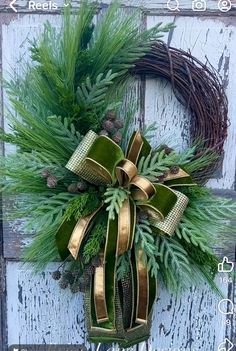 a green wreath with gold ribbon hanging on a door