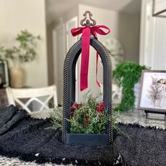 a small mirror with a red bow on it sitting on top of a black table cloth