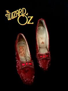 the wizard's red shoes are on display in front of a black background with gold lettering