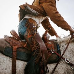 a man riding on the back of a brown and white horse next to another person