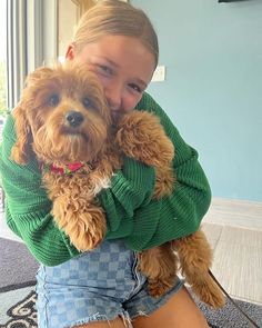 a girl holding a dog in her arms