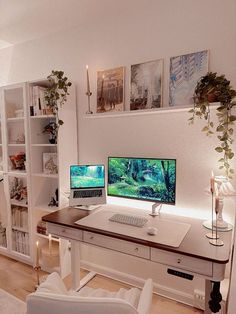 a desk with two computers on it in front of a bookshelf filled with plants