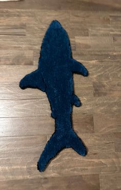 a blue shark rug laying on top of a wooden floor