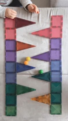 a child is playing with an art project made out of plastic blocks and colored shapes