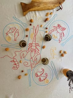 an embroidered tablecloth with fish, shells and other items