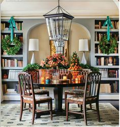 the dining room table is surrounded by bookshelves and wreaths