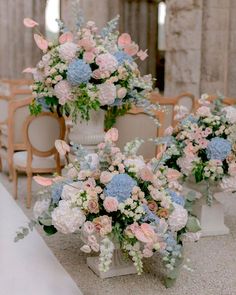 there are many flowers in the vases on the tables at this wedding ceremony,