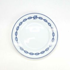 a white and blue plate with a chain around the edge on a white tablecloth