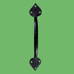 a black iron door handle on a green background