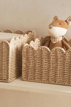 two baskets with stuffed animals in them on a shelf