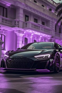 a black and purple sports car parked in front of a building with lights on it