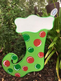 a green christmas stocking with red and green polka dots on it sitting in the grass