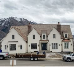 a house being moved by a truck in front of it with mountains in the background