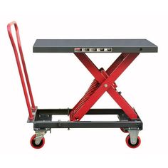 a red scissor sitting on top of a table with two handles and wheels