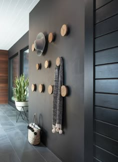 a wall with several wooden circles on it and a potted plant next to it