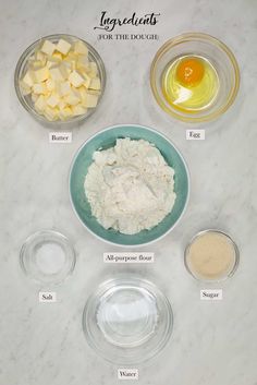 ingredients to make an egg salad laid out on a marble counter top, including eggs and butter