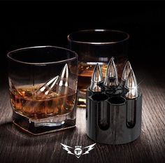 an image of two glasses with ice cubes on the side and one glass filled with whiskey