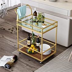 a bar cart with bottles and glasses on it in the middle of a living room