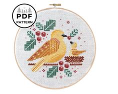 a cross stitch pattern with two birds sitting on a branch