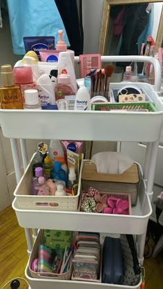 a white cart filled with lots of different types of cosmetics and personal care products on top of a hard wood floor