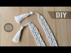 two pieces of white lace with tassels on top of a wooden table next to a sign that says diy