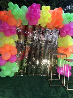 an arch made out of balloons is shown in front of a green carpeted area