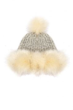 a knitted hat with fur pom - poms