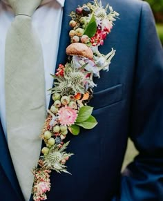 a man wearing a suit and tie with flowers on his lapel flower garlands