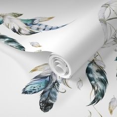 a white wallpaper with blue and green feathers on it