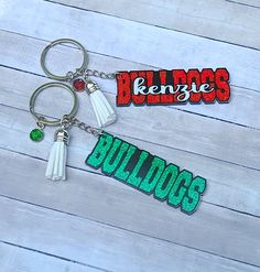 two key chains with the word bulldogs on them, one is green and the other is red