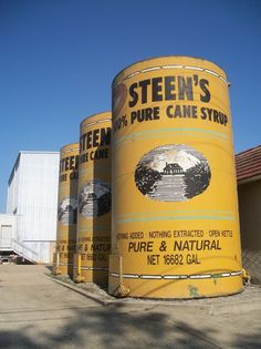 three large yellow barrels sitting in front of a building