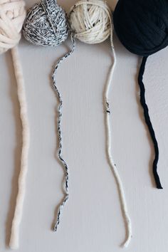 three skeins of yarn sitting on top of a white table next to each other