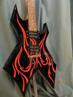 a black and red guitar with flames on it