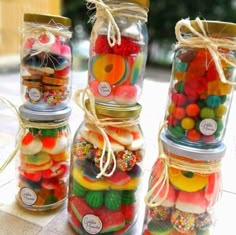 four jars filled with different types of candies