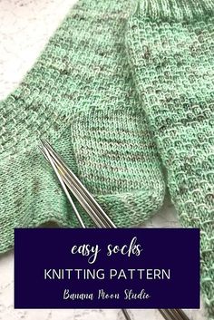 the knitting needles are next to some green knitted sweaters with text overlay that says easy socks knitting pattern