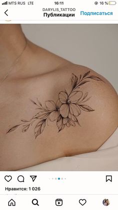 a woman's chest with flowers and leaves tattooed on the top of her breast