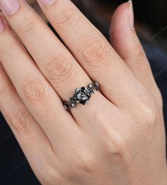 a woman's hand with a black and white diamond ring on her left hand