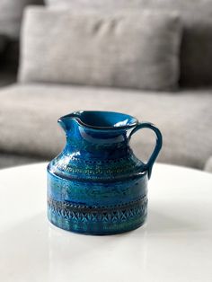 a blue vase sitting on top of a white table