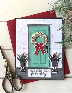 a green door with a red bow on it and some scissors sitting next to it