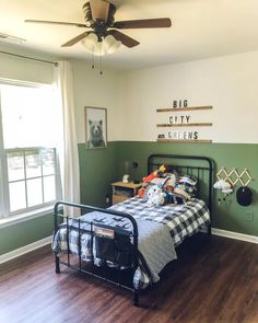 a bed room with a neatly made bed next to a window and a ceiling fan