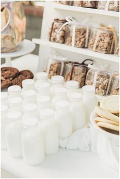 there are many cookies and milks on the table in front of the dessert bar