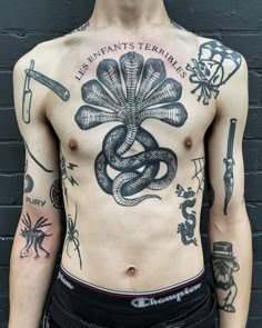 a man with tattoos on his chest has a snake and dagger tattoo on his chest