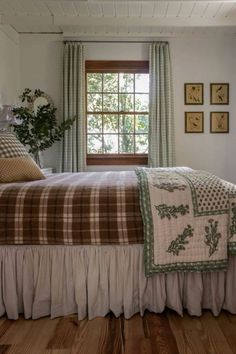 a bed sitting under a window in a bedroom next to a wooden floor and wall