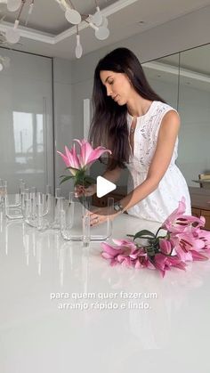 a woman arranging flowers on a counter top