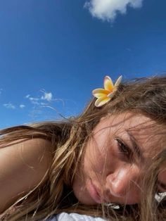 a girl with long hair and a flower in her hair is posing for the camera