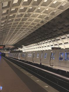 a silver train traveling through a train station